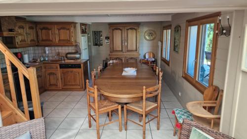 a kitchen with a wooden table and chairs at Le Domaine de la Répandise in Laveline-du-Houx