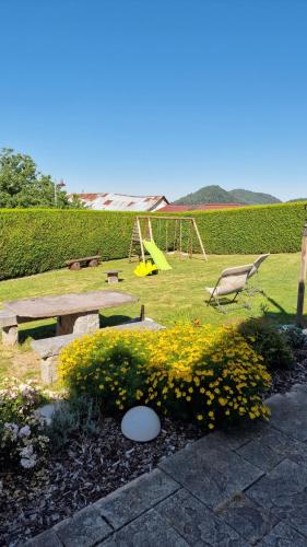 a park with a bird and flowers and a swing at Le Domaine de la Répandise in Laveline-du-Houx