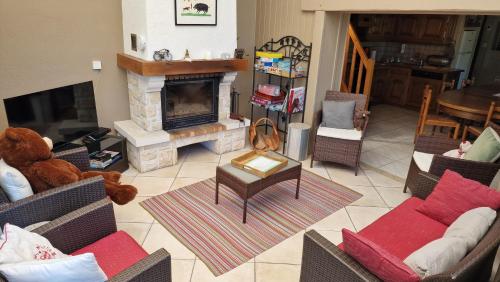 a living room with a teddy bear and a fireplace at Le Domaine de la Répandise in Laveline-du-Houx