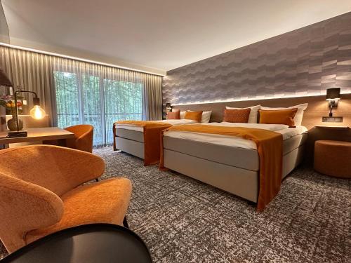 a hotel room with two beds and a chair at Hotel Gladbeck van der Valk in Gladbeck