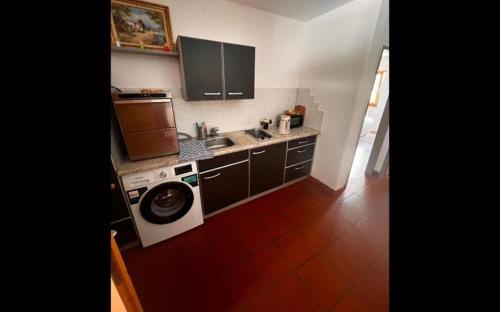 a kitchen with a washing machine and a washer at Alexandra Alber Villa Schlosskopf in Sankt Anton am Arlberg