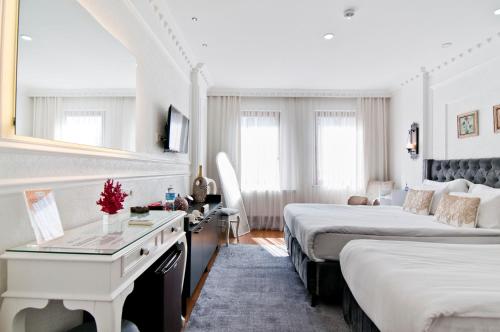 a hotel room with two beds and a desk at Sadaret Hotel-Old City Sultanahmet in Istanbul