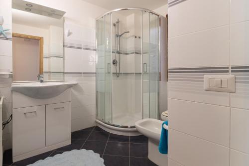 Un baño con ducha, lavabo e inodoro. en Villa Valeria - 6min walk to the sea, en Costa Rei