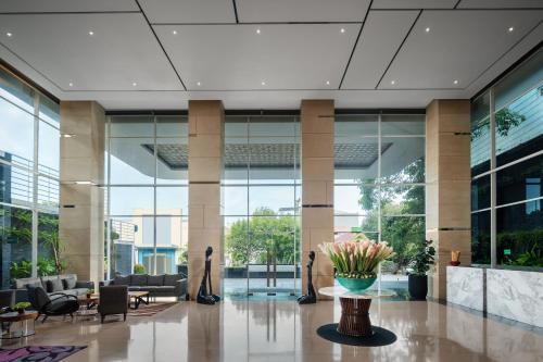 a lobby with chairs and a vase of flowers at Melia Makassar in Makassar