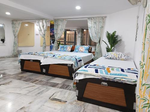 a bedroom with two beds and a mirror at Stay Reliable in Udaipur