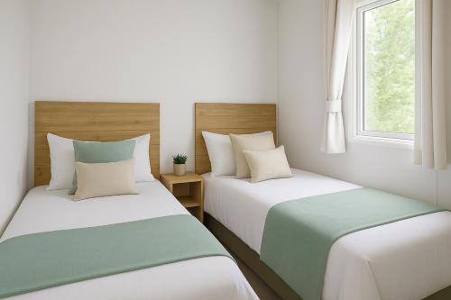 two beds in a room with white and green at Morsh Luxury Caravan Getaway in Colchester