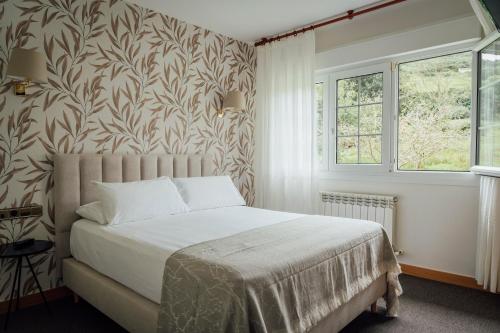 a bedroom with a bed and a wall mural at Hotel San Jorge in Nueva de Llanes