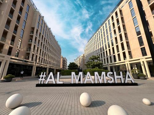 a large metal sign in front of a building at 1BR Private Apartment - Perfect Home in Sharjah Intl