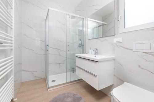 a white bathroom with a shower and a sink at Villa Hidden with heated pool in Dobrinj