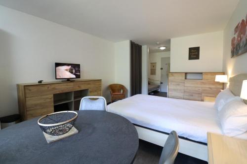 ein Hotelzimmer mit einem Bett und einem Tisch in der Unterkunft Appartement Belle étoile - Cure, ski & spa in Brides-les-Bains