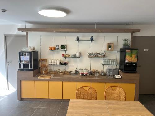 a kitchen with a counter with aasteryasteryasteryasteryasteryasteryasteryasteryastery at Brit Hotel Essentiel Millau in Millau