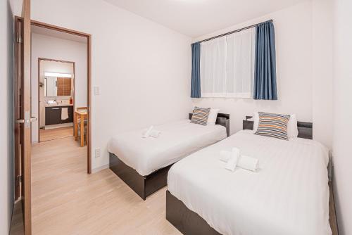 a hotel room with two beds and a mirror at Bright Modern Airbnb in Tokyo's Northern District in Tokyo