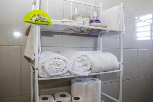 einen Handtuchhalter mit Handtüchern und Toilettenpapier im Bad in der Unterkunft 4 Bedroom 3 Bathroom Outdoor Terrace with Amazing View in Willemstad