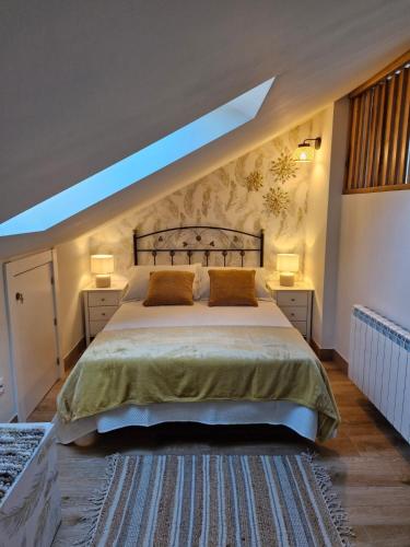 a bedroom with a bed with two pillows on it at "La casuca de Finu" #2# Santillana del Mar in Santillana del Mar