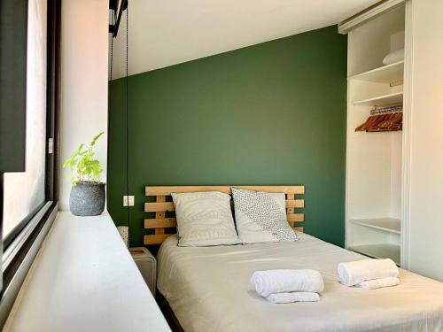 - 2 lits dans une chambre avec un mur vert dans l'établissement Appartment with pool, beach and ocean 5 min by walk, city center, shopping and market, à Vieux-Boucau-les-Bains