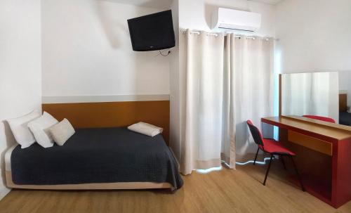 a bedroom with a bed and a desk with a computer at Hotel Joao XXI in Braga