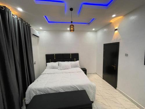 a bedroom with a large bed with a blue ceiling at Sweet Apartment in Ibadan in Ibadan
