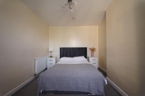 a bedroom with a bed and two dressers in it at Maidstone Gem Walk to Shops in Maidstone