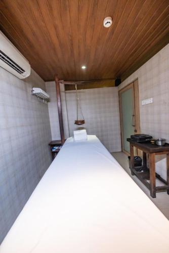 a large bed in a room with a wooden ceiling at Neelam's The Grand Hotel Goa in Calangute
