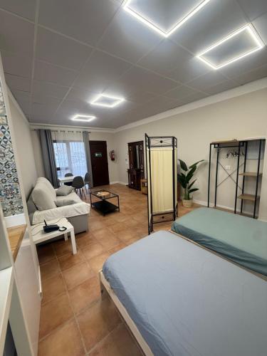 a bedroom with a bed and a living room at Puerta de Hierro Loft boutique in Badajoz