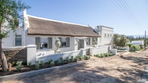a white house with a thatched roof at La Maison du Canard in McGregor