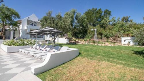 a group of white chairs sitting on a lawn at La Maison du Canard in McGregor