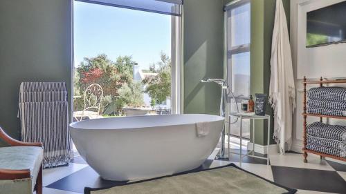 a bath tub in a bathroom with a large window at La Maison du Canard in McGregor