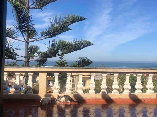 a group of people sitting on a balcony looking at the ocean at Villa Jacuzzi à 200m de la plage Tamaris in Dar Bouazza