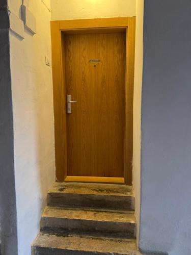 a wooden door in a building with stairs at Apartments Manzini in Koper