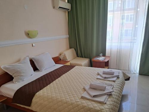a hotel room with a bed with towels on it at Guest House Paskal in Sunny Beach