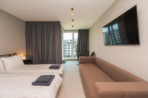 ein Hotelzimmer mit zwei Betten und einer Couch in der Unterkunft Eleve Residences - Obsidian Studios in Sofia