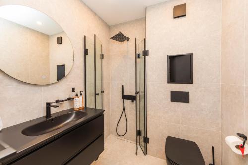 ein Badezimmer mit Waschbecken und Spiegel in der Unterkunft Eleve Residences - Obsidian Studios in Sofia