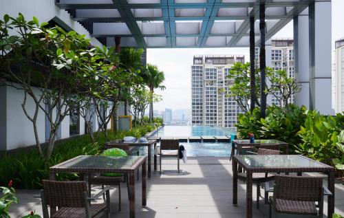 an outdoor patio with tables and chairs and a pool at Pavilion Bukit Jalil Revo Aurora Walk to Mall & Near Axiata Arena by D'Summer 28A in Kuala Lumpur