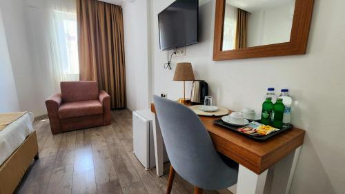 a hotel room with a table with drinks and a chair at Karden Otel in Antalya