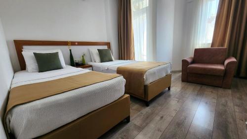 a hotel room with two beds and a chair at Karden Otel in Antalya