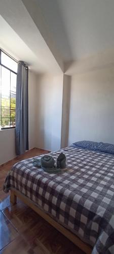 a bedroom with a bed with a checkered blanket at Hospedaje Dase in Oxapampa