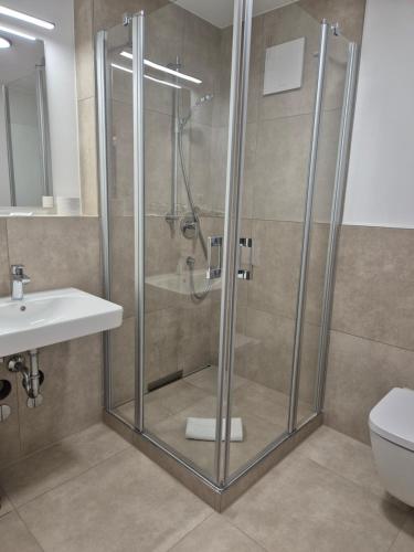a shower with a glass door in a bathroom at Hotel Garni Kern in Halfing