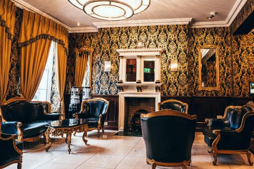 a salon with chairs and a table and a fireplace at Russell Court Hotel in Dublin