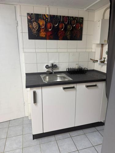 a kitchen with white cabinets and a sink at Apartment Heidchen in Knüllwald