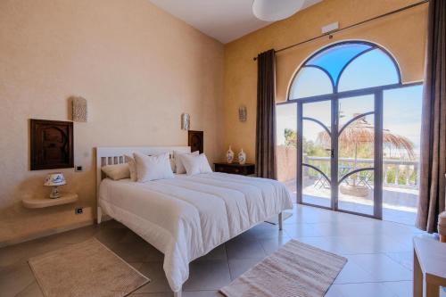 a bedroom with a large bed and a large window at Villa Sultana by Living Essaouira in Essaouira