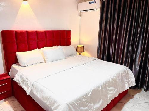 a bedroom with a large bed with a red headboard at Exquisite 3Bedroom in Ibadan in Ibadan