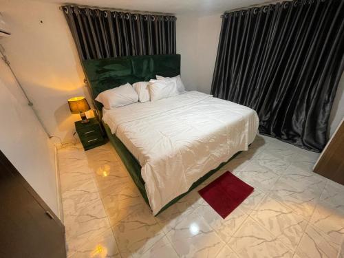a bedroom with a white bed with a window at Exquisite 3Bedroom in Ibadan in Ibadan