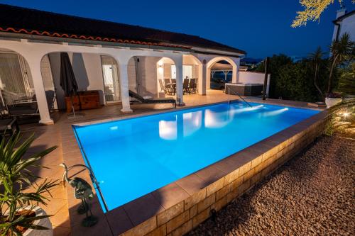 a swimming pool in front of a house at Casa Bianca in Barbat na Rabu
