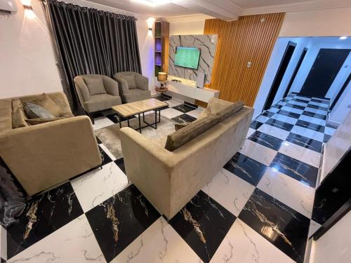 a living room with a couch and a checkerboard floor at Exquisite 3Bedroom in Ibadan in Ibadan