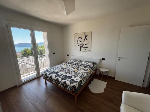 ArizzanoにあるModerno appartamento vista sul lago Maggioreのベッドと大きな窓のある寝室