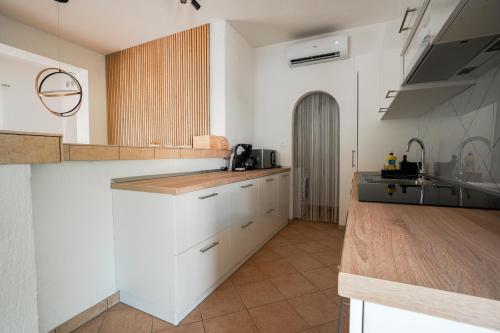 a kitchen with white cabinets and a counter top at Casa Bianca in Barbat na Rabu