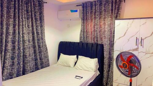 a bedroom with a bed with a fan and curtains at TemiHOUSE40 in Ibadan