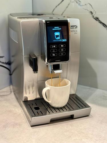 a coffee maker with a cup on top of it at SeaUSasino - Luksusowe Drewniane Domy z Kominkami in Sasino