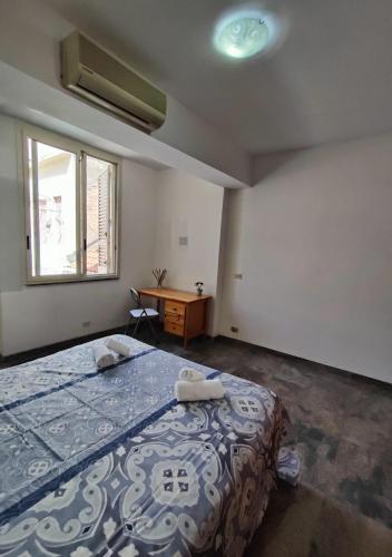 a bedroom with a bed and a desk and a window at Casa Vacanze A Due Passi Dal Mare in Furci Siculo
