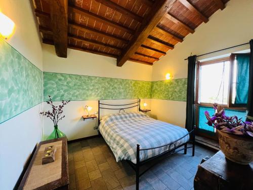 a bedroom with a bed and a table and a window at Agriturismo Le Ceregne Bio in Pieve Santo Stefano